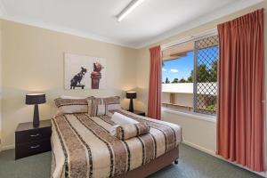 1 dormitorio con cama y ventana en Clifford Park Motor Inn, en Toowoomba