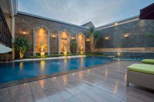 a swimming pool in front of a building at Prima In Hotel Malioboro in Yogyakarta