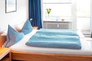 ウィトデュンにあるSeelöwe App. 9のベッドルーム1室(青と白の枕が備わるベッド1台付)