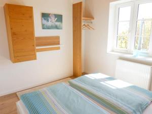 a bed in a room with a window at Haus Nordlicht Ferienwohnung *At Nuurdlacht* in Nebel