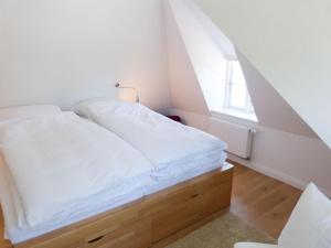 a white bed in a room with a window at Ruard Waanang in Nebel