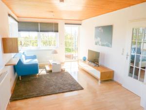 a living room with a blue chair and a tv at Haus Nordlicht Ferienwohnung *At Nuurdlacht* in Nebel