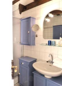 ein Badezimmer mit einem Waschbecken und einem blauen Schrank in der Unterkunft Hüs Sanskiin Ferienwohnung *Driiwholt* in Süddorf