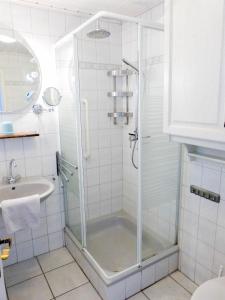 a bathroom with a shower and a sink at Hüs Sanskiin Ferienwohnung *Hopelfask* in Süddorf