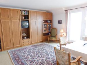 a living room with a tv and a table and chairs at Haus Leitfeuer Whg. 19 in Wittdün