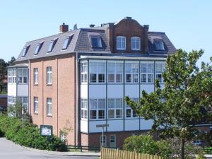 duży ceglany budynek z mnóstwem okien w obiekcie Haus Therese *FeWo 7* w mieście Wittdün