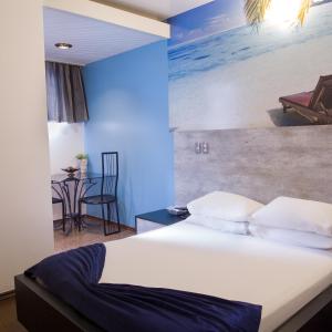 Rainbow Motel (Adult Only) في إتوبيفا: غرفة نوم بسرير مع لوحة على الشاطئ