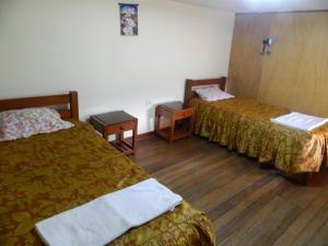 ein Hotelzimmer mit 2 Betten und 2 Tischen in der Unterkunft Wichana Wasi in Cusco