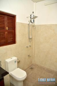 a bathroom with a toilet and a shower at Lake Near in Tissamaharama