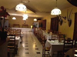 a dining room with white tables and chairs and chandeliers at Bel Air in Marville