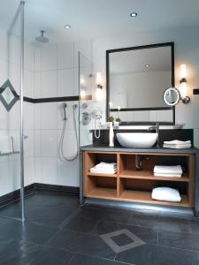 a bathroom with a sink and a mirror at Land- und Kurhotel Tommes in Schmallenberg