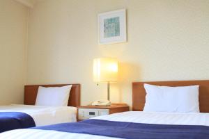 Postel nebo postele na pokoji v ubytování Shonandai Daiichi Hotel Fujisawa Yokohama