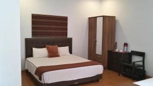 a bedroom with a bed and a dresser in it at Amazon Bungalow & Cottages in Batukaras