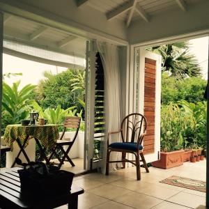 a porch with two chairs and a table on it at smithy's eco-apartment in Morne Jaloux Ridge