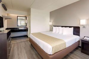 a hotel room with a large bed and a bathroom at Travelodge by Wyndham College Park in Atlanta