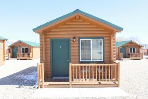 a log cabin with a blue door and a porch at Bryce Valley Lodging in Tropic