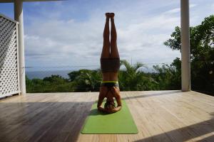 Una donna che fa una posa yoga su un tappetino da yoga di Little Tamarind a Tangalle