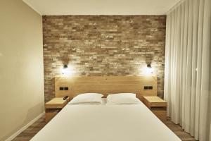 a bedroom with a large bed and a brick wall at Hotel Miramonti in Schio