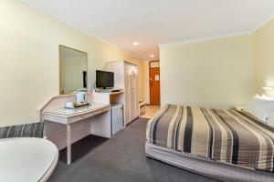 a hotel room with two beds and a television at William Macintosh Motor Lodge in Naracoorte
