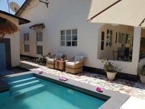 a swimming pool in the backyard of a house at Mandinka Lodge in Kololi