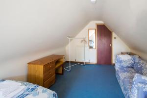 a attic room with a bed and a wooden desk at Dairy Cottage in Ayr