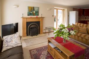 un salon avec un canapé et une cheminée dans l'établissement Dairy Cottage, à Ayr