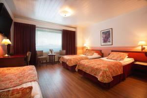 a hotel room with two beds and a table at Hotel Milton in Jyväskylä