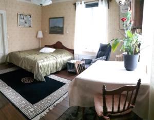 ein Schlafzimmer mit einem Bett und einem Tisch in einem Zimmer in der Unterkunft Lottas Rum in Smedjebacken