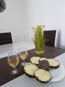 a table with two glasses of wine and a plate of food at Apartament Piratininga in Niterói