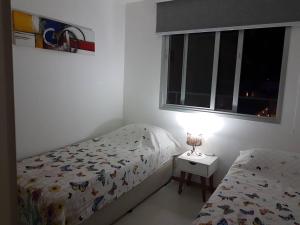 a bedroom with two beds and a window at Apartament Piratininga in Niterói +36 photos