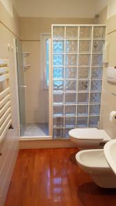 uma casa de banho com 2 WC e uma cabina de duche em vidro. em Villa Olimpo em Rapallo