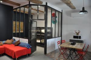 Habitación con cama y mesa con sillas. en Rouge Pompon, en Mèze