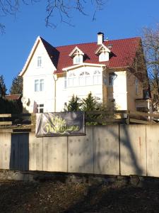 ein weißes Haus mit einem Schild davor in der Unterkunft Villa Pusteblume in Bad Grund