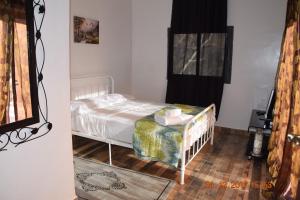 Schlafzimmer mit einem weißen Bett und Holzboden in der Unterkunft Mountain Paradise Chalet in Imlil