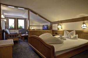 um quarto de hotel com uma cama grande com almofadas brancas em Hotel Gemma- Adults only em Hirschegg