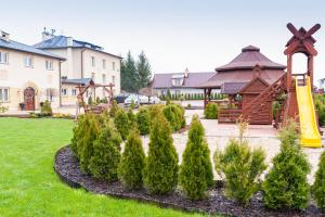 a garden with trees and a playground in front of a building at Hotel Andersen in Rzeszów