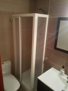 y baño con ducha, aseo y lavamanos. en Apartamento En Benidorm, en Benidorm