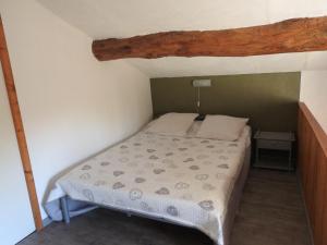 um pequeno quarto com uma cama num quarto em La Nichoule em Rosières