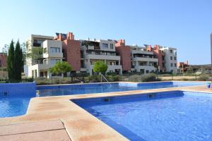 uma grande piscina com edifícios ao fundo em Corvera Golf and Country Club em Corvera