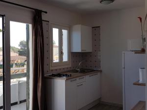 a kitchen with a sink and a refrigerator at Apartaments California in Cala en Blanes