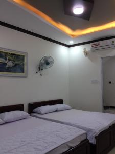 a bedroom with two beds and a fan at Khách sạn Thu Thảo in Phan Rang