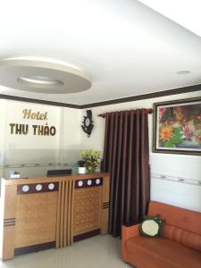 a living room with a couch and a hotel thrullo sign at Khách sạn Thu Thảo in Phan Rang