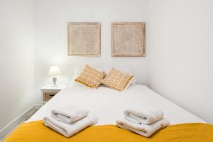 Un dormitorio con una cama blanca con toallas. en Stay U-nique Apartments Rossello, en Barcelona