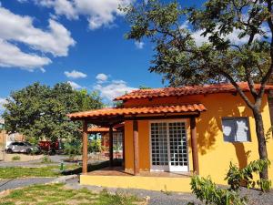 a small yellow building with a red roof at Pousada e Chales Mambaí Inn in Mambaí
