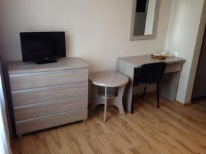 a room with a desk and a table and a television at Hotel Piast in Myślibórz