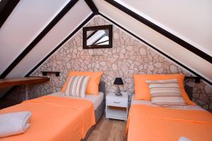 two beds in the attic bedroom of a house at Apartments & Rooms As in Vis