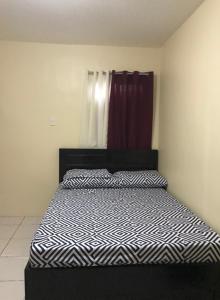 a bedroom with a bed with a black and white comforter at RV3 TRANSIENT HOUSE in Angeles