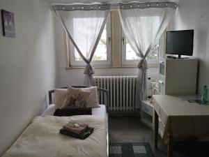 a small bedroom with a bed and a window at pension sonne in Ulm