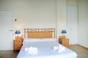 1 dormitorio con 1 cama grande con sábanas y almohadas blancas en Gala 3, en Tamariu