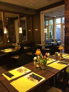 a dining room with a table with flowers on it at Apple Inn Hotel in Amsterdam